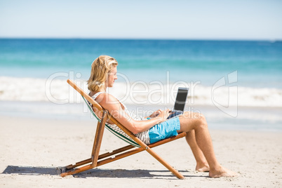 Man sitting on armchair at beach