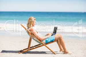 Man sitting on armchair at beach