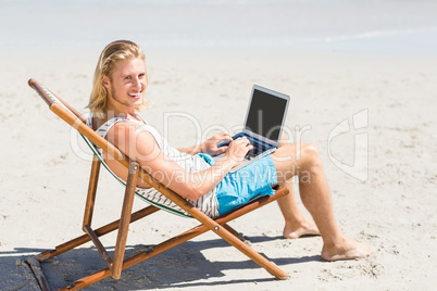 Man sitting on armchair at beach