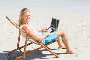 Man sitting on armchair at beach