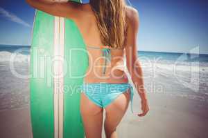 Woman standing with surfboard on beach