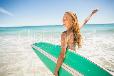 Woman posing with surfboard on beach