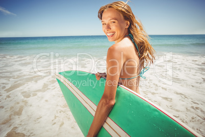 Woman holding surfboard on beach