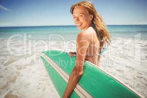 Woman holding surfboard on beach