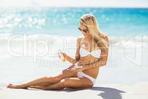Woman applying sun cream on her leg