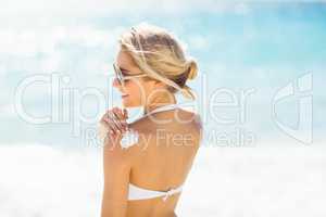 Woman applying sun cream on her shoulder