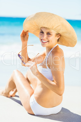 Young woman in bikini sitting on beach