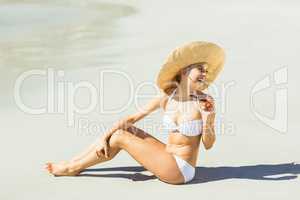 Young woman in bikini sitting on beach