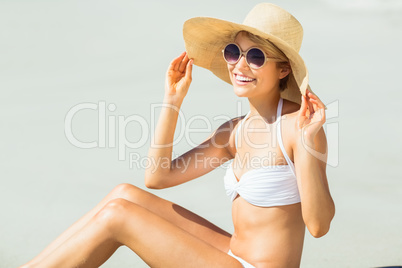 Young woman in bikini posing with hat