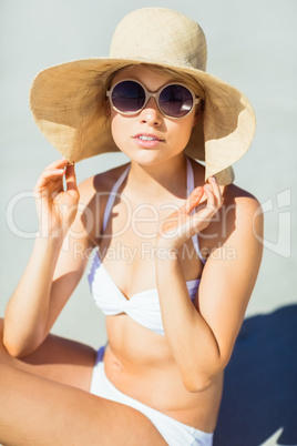 Young woman in bikini posing with hat