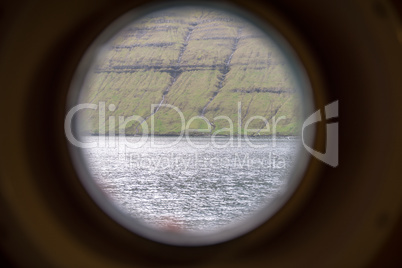 Landscape of the faroe island as seen through a porthole