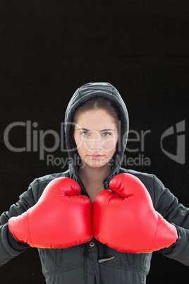 Composite image of sportswoman is wearing boxing glove