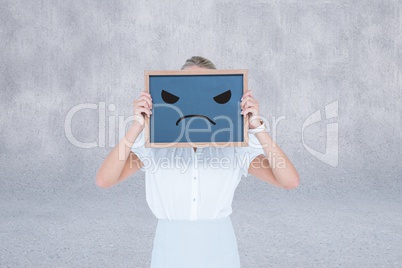 Compositeimage of woman is holding a chalkboard with unsmiling f