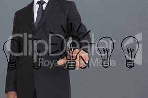 Composite image of businessman is touching drawn bulb