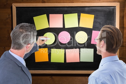 Composite image of businessman is writing on a board