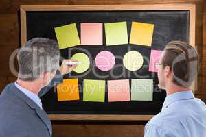 Composite image of businessman is writing on a board