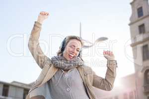 Composite image of happy woman is listening music