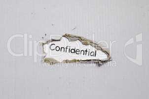 The word confidential appearing behind torn paper.