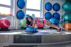 Image of pretty woman doing push-ups in gym