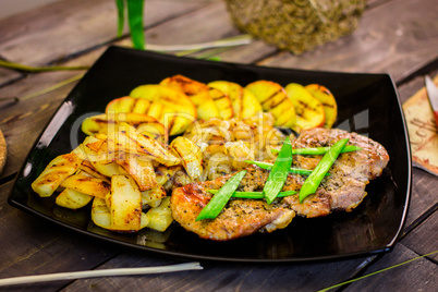 Pork steak with grilled potatoes and zucchini