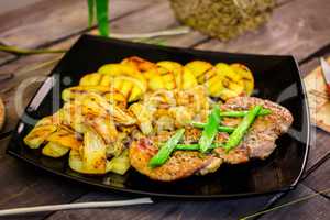 Pork steak with grilled potatoes and zucchini