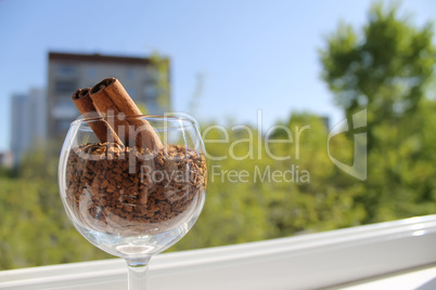 cinnamon sticks in wine glass with granulated coffee
