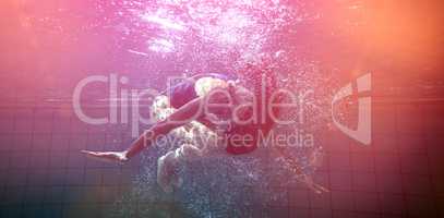 Athletic swimmer doing a somersault underwater