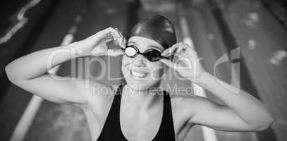 Woman in swimsuit adjusting her goggles