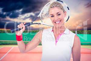 Composite image of portrait of happy athlete holding racquet