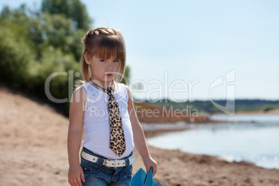 Serious little model posing on lake background