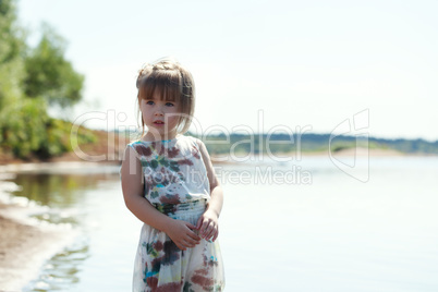 Adorable little model posing on lake backdrop