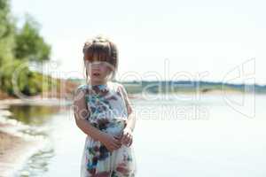 Adorable little model posing on lake backdrop