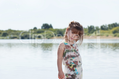 Smiling little girl posing by river