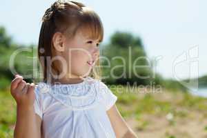 Portrait of merry little girl posing in park