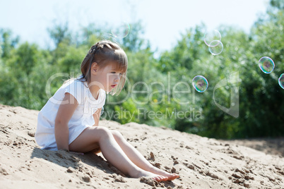 Curious little model sitting on sand in park