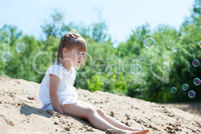 Surprised girl looking at soap bubbles in park