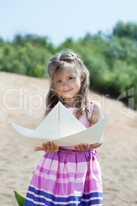 Cute little girl posing with paper boat