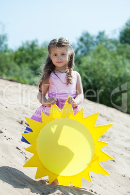 Beautiful little girl posing with paper sun