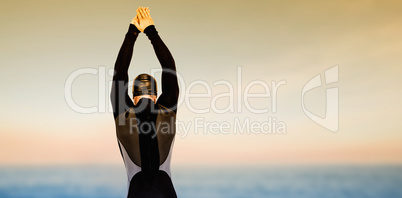 Composite image of rear view of swimmer in wetsuit while diving