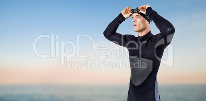 Composite image of swimmer in wetsuit wearing swimming goggles