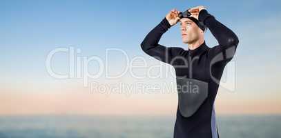 Composite image of swimmer in wetsuit wearing swimming goggles