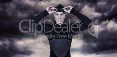 Composite image of swimmer in wetsuit wearing swimming goggles