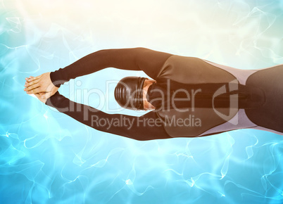 Composite image of rear view of swimmer in wetsuit while diving