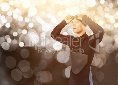 Composite image of swimmer in wetsuit wearing swimming goggles