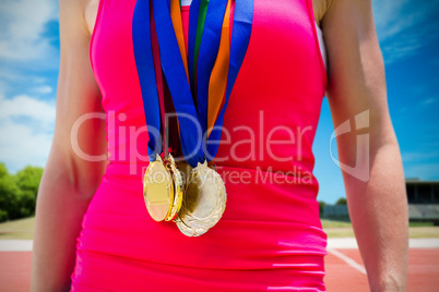 Composite image of portrait of sportswoman chest with medals