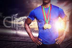 Composite image of portrait of athletic man chest holding gold m