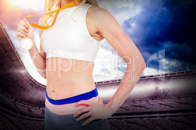 Composite image of athlete holding gold medal after victory