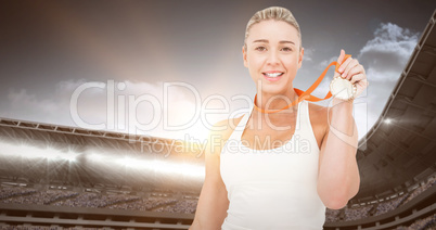 Composite image of happy female athlete holding medal