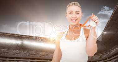 Composite image of happy female athlete holding medal
