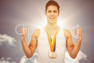 Composite image of athlete posing with gold medal after victory